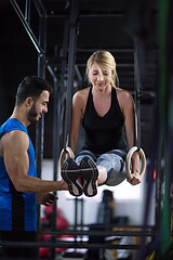 Image showing woman working out with personal trainer on gymnastic rings