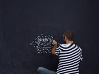 Image showing future dad drawing his imaginations on chalk board