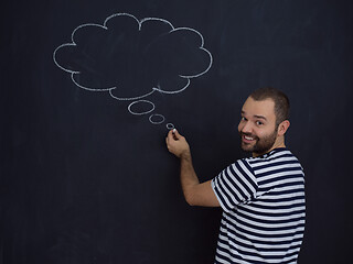 Image showing young future father thinking in front of black chalkboard