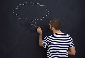 Image showing young future father thinking in front of black chalkboard