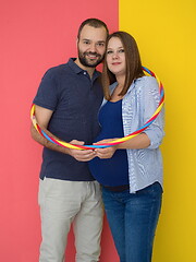 Image showing pregnant couple  isolated over colorful background