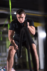 Image showing athlete man doing battle ropes cross fitness exercise