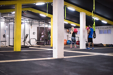 Image showing young athletes couple working out with medical ball