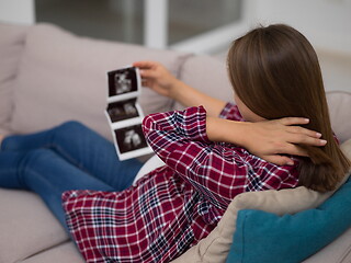 Image showing pregnant woman looking baby\'s ultrasound