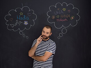 Image showing young future father thinking in front of black chalkboard