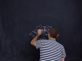 Image showing future dad drawing his imaginations on chalk board