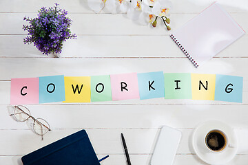 Image showing COWORKING. Message at colorful note papers on a desk background.