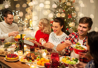 Image showing happy friends having christmas dinner at home