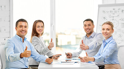 Image showing happy business team showing thumbs up at office