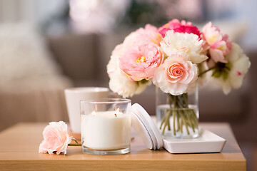 Image showing burning candle and flower bunch on wooden table