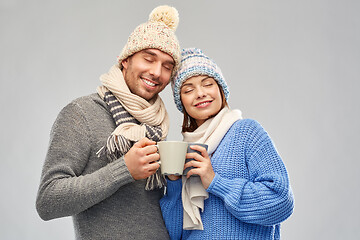 Image showing happy couple in winter clothes with mugs