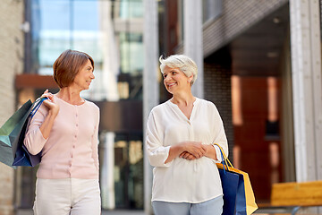 Image showing senior women with shopping bags walking in city