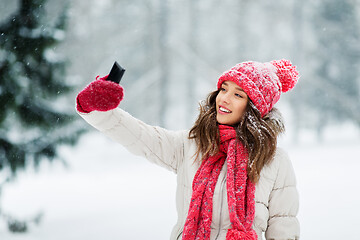 Image showing young woman taking selfie by smartphone in winter
