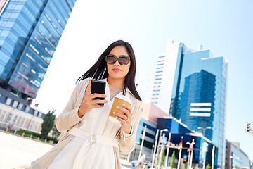 Image showing smiling woman with smartphone and coffee in city