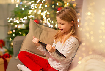 Image showing smiling girl with tablet pc at christmas home