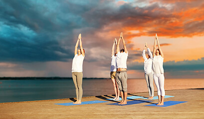 Image showing group of people making yoga exercises outdoors