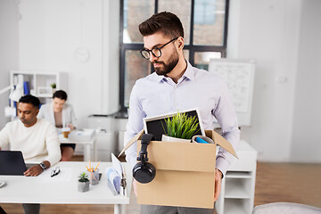 Image showing sad fired male office worker with personal stuff