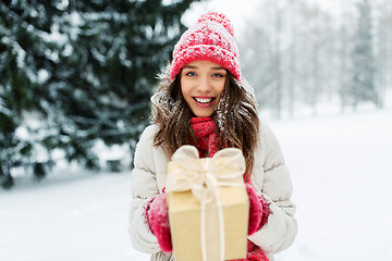 Image showing happy young woman with christmas gift in winter