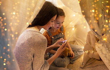 Image showing happy family with smartphone in kids tent at home