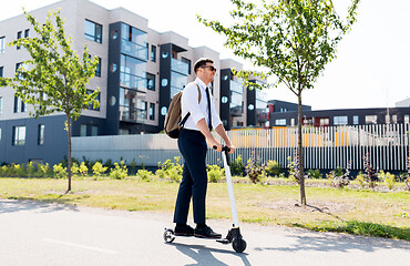 Image showing businessman with backpack riding electric scooter