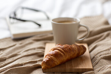 Image showing croissant and cup of coffee on bed at cozy home