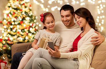 Image showing family with smartphone at home on christmas