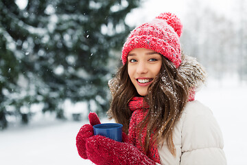 Image showing happy young woman with tea cup in winter park