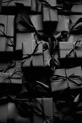 Image showing A pile various size black boxed gifts placed on stack. Christmas concept.