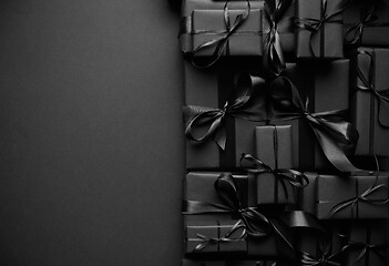 Image showing A pile various size black boxed gifts placed on stack. Christmas concept.