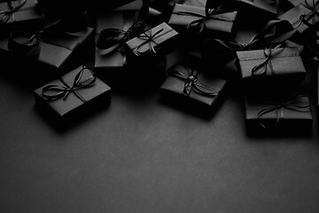 Image showing A pile various size black boxed gifts placed on stack. Christmas concept.