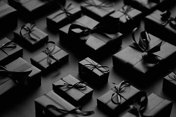 Image showing Elegant black Christmas theme. Wrapped gifts in black matte paper with ribbon