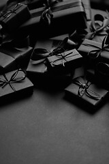 Image showing A pile various size black boxed gifts placed on stack. Christmas concept.