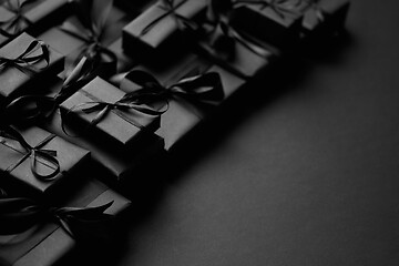 Image showing A pile various size black boxed gifts placed on stack. Christmas concept.