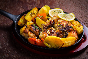 Image showing Baked lemon chicken with potatoes, carrots and herbs served in pan