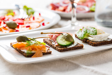 Image showing Variation of healthy open sandwiches on Pumpernickel bread with vegetables, salmon, Prosciutto and appetizers