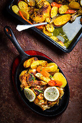 Image showing Baked lemon chicken with potatoes, carrots and herbs served in pan