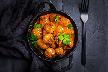 Image showing Meatballs with tomato sauce in black pan