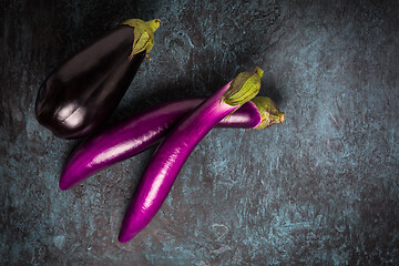 Image showing Assortment of fresh aubergines on dark background