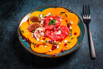 Image showing Persimmon carpaccio salad with pomegranate, feta cheese, pink grapefruit and figs