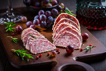 Image showing Saltufo - Italian salami delicacy, salami with summer truffle coated with Parmesan cheese with red wine and grapes