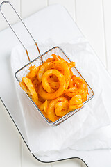 Image showing Spicy seasoned curly fries. Ready to eat.