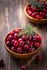 Image showing Ripe organic cranberries in wooden bowl on wooden background