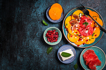 Image showing Persimmon carpaccio salad with pomegranate, feta cheese, pink grapefruit and figs