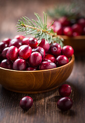 Image showing Ripe organic cranberries in wooden bowl on wooden background