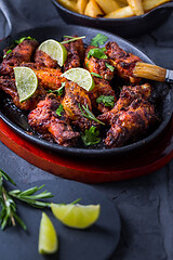 Image showing Roasted chicken wings in barbecue sauce with lime and baked potatoes