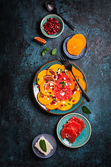 Image showing Persimmon carpaccio salad with pomegranate, feta cheese, pink grapefruit and figs