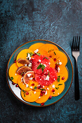 Image showing Persimmon carpaccio salad with pomegranate, feta cheese, pink grapefruit and figs