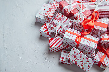 Image showing A pile various size wrapped in festive paper boxed gifts placed on stack. Christmas concept