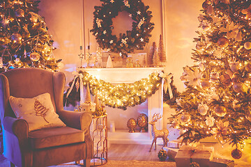 Image showing Beautiful Christmas interior decoration for family celebration with pine tree, armchair, fireplace