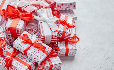 Image showing Various pattern and size Christmas boxes placed on white background. Wrapped in festive paper